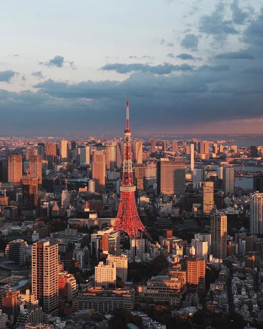 Stunning aerial view of Tokyo Tower with the cityscape under a dramatic sunset sky.